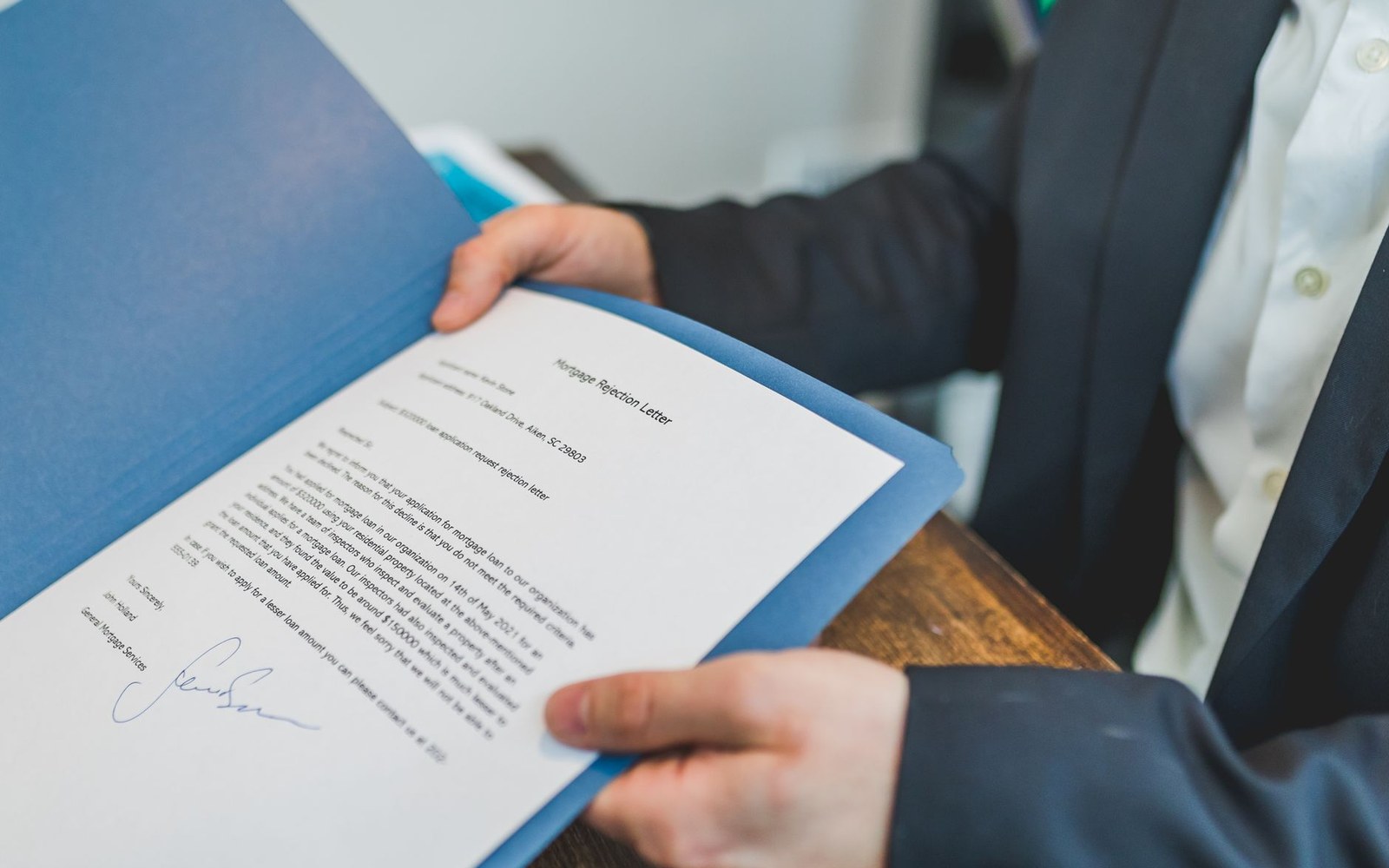 Close crop of a printed FTC complaint, open to the relief section, a hand holding the page flat